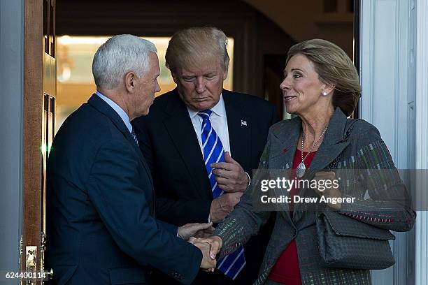Vice president-elect Mike Pence, president-elect Donald Trump and Betsy DeVos leave the clubhouse after their meeting at Trump International Golf...