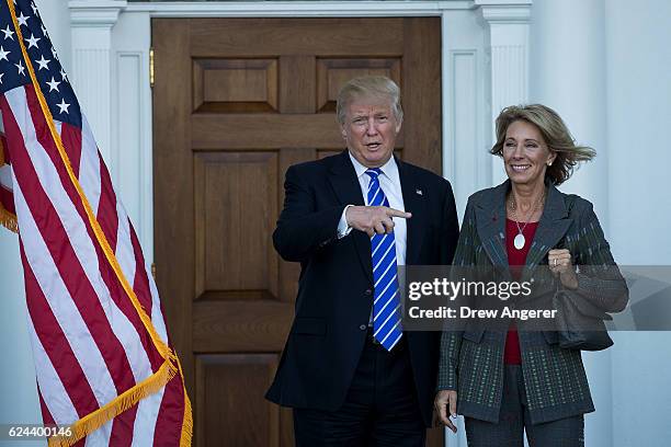 President-elect Donald Trump and Betsy DeVos pose for a photo after their meeting at Trump International Golf Club, November 19, 2016 in Bedminster...