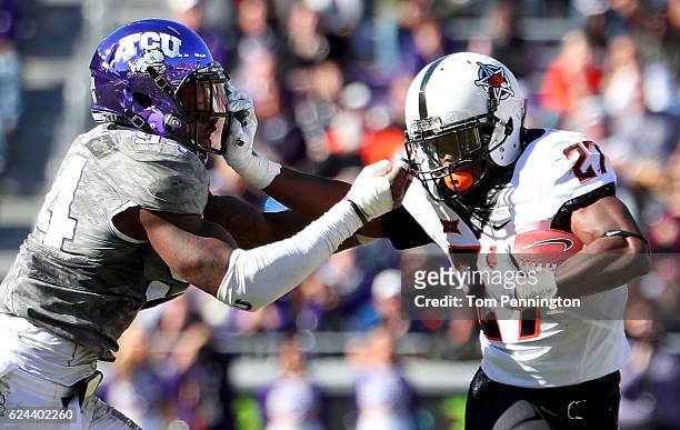 Justice Hill of the Oklahoma State Cowboys carries the ball against Josh Carraway of the TCU Horned Frogs in the second half at Amon G. Carter...