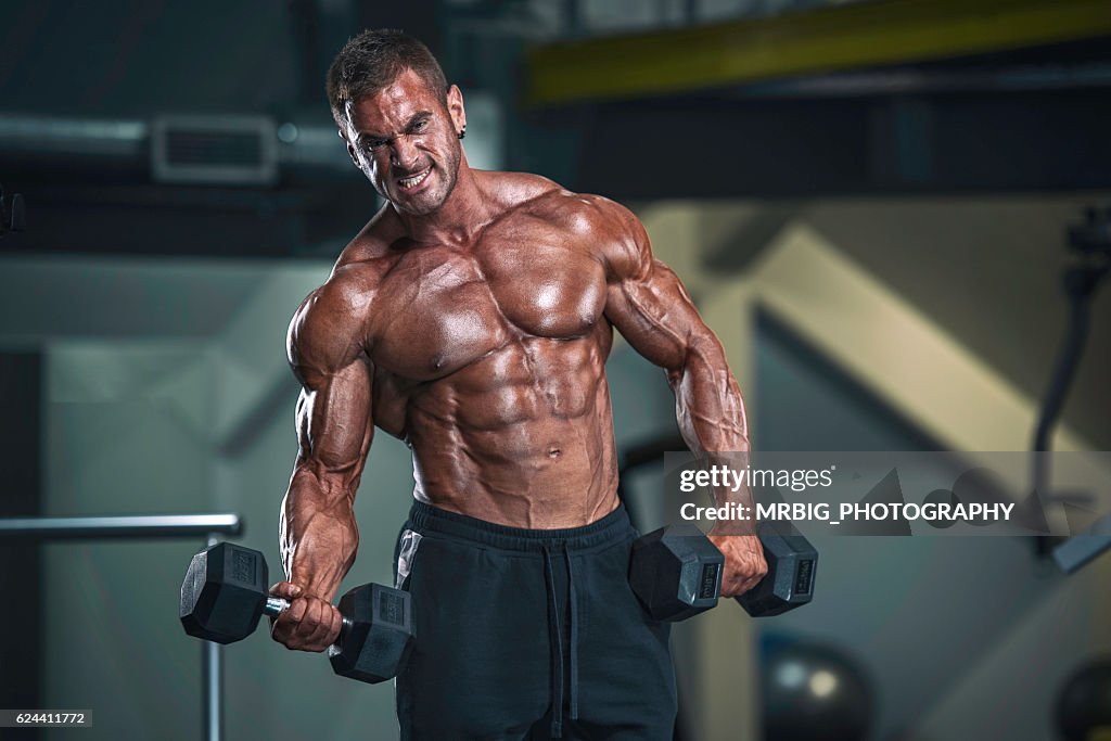 Strong, Muscular Men Exercise With Dumbbells