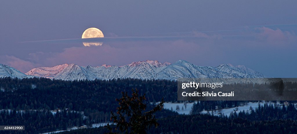 Full super moon over the Alps at sunrise