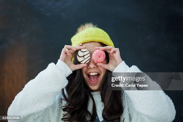 girl with pink donuts in front of her eyes - fat people eating donuts foto e immagini stock