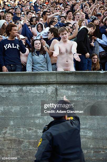 Naked fan talks with a policeman during the game between the Yale Bulldogs and the Harvard Crimson at Harvard Stadium on November 19, 2016 in Boston,...