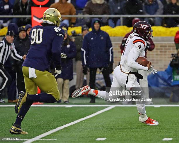 Jerod Evans of the Virginia Tech Hokies uns for touchdown chased by Isaac Rochell of the Notre Dame Fighting Irish at Notre Dame Stadium on November...