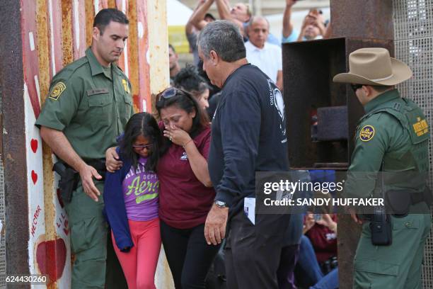 Laura Avila hugs her daughter Laura Vera Martinez after seeing relatives in Mexico when they were allowed to meet after a door was opened along the...