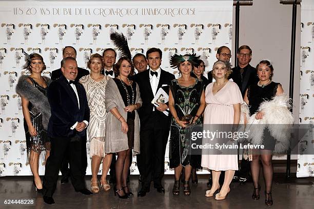 Artcurial auctioneer Stephane Aubert poses for photocall with Red Cross members as he arrives for the 20th Luxembourg Red Cross Ball Gala on November...