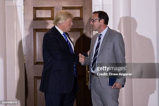 President-elect Donald Trump shakes hands with Todd Ricketts, co-owner of the Chicago Cubs, after their meeting at Trump International Golf Club,...