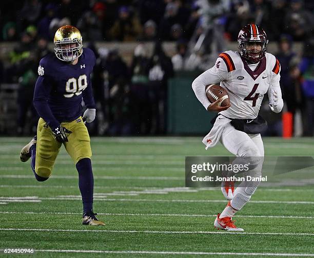 Jerod Evans of the Virginia Tech Hokies runs for a first down chassed by Jerry Tillery of the Notre Dame Fighting Irish at Notre Dame Stadium on...