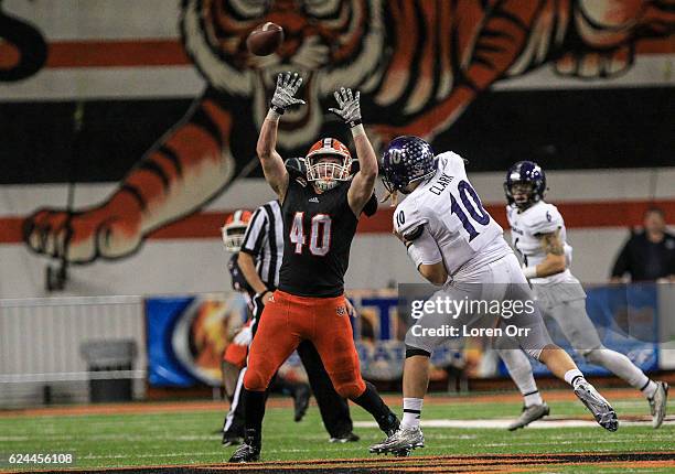 Quarterback Jadrian Clark of the Weber State Wildcats gets a pass off in the face of defensive pressure from linebacker Jake Pettit of the Idaho...