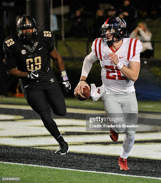 Quarterback Shea Patterson of the Ole Miss Rebels rolls out against Adam Butler of the Vanderbilt Commodores during the first half at Vanderbilt...