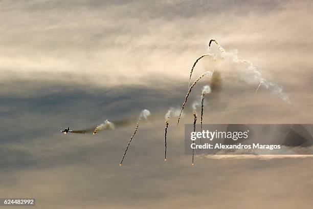 fighter plane releases flares - alexandros maragos stock pictures, royalty-free photos & images