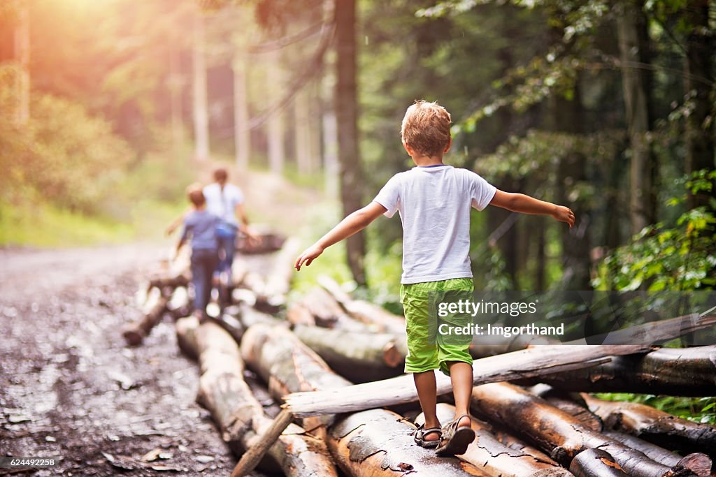 Niños balanceándose en troncos de árboles