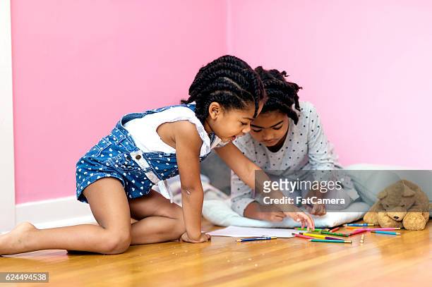 jeunes sœurs afro-américaines jouant sur un plancher en bois - fat twins photos et images de collection