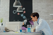 Researcher Using Microscope In Her Lab.
