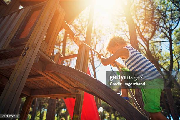 little boy climbing on the playground - child slide stockfoto's en -beelden