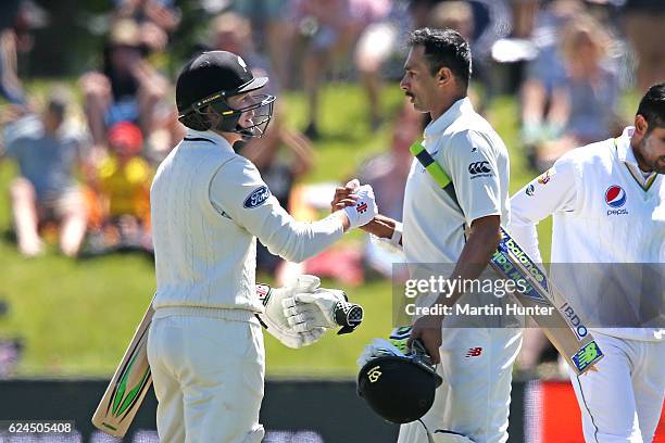 Henry Nicholls of New Zealand congratulates team mate Jeet Raval after day four of the First Test between New Zealand and Pakistan at Hagley Oval on...