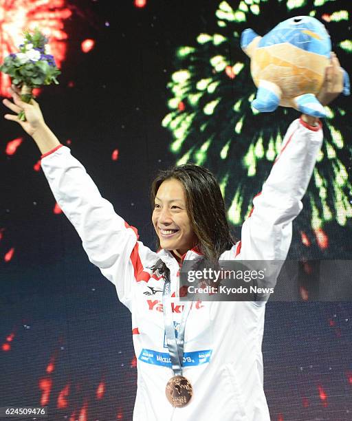 Spain - Japan's Aya Terakawa at the award ceremony acknowledges cheers with the bronze medal she won in the women's 50-meter backstroke at the world...