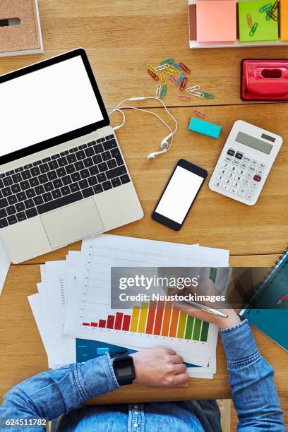 geschäftsfrau untersucht balkendiagramm am holztisch - assessment graph stock-fotos und bilder