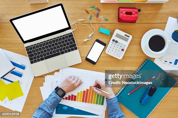 geschäftsfrau analysiert balkendiagramm am holztisch - assessment graph stock-fotos und bilder