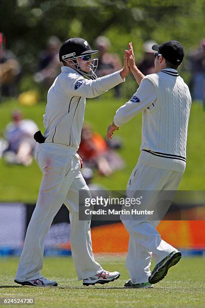 Tom Latham of New Zealand celebrates with team mate Todd Astle during day four of the First Test between New Zealand and Pakistan at Hagley Oval on...