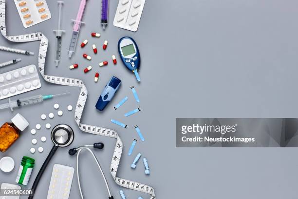 flat lay of various medical supplies on gray background - diabetes pills stock pictures, royalty-free photos & images