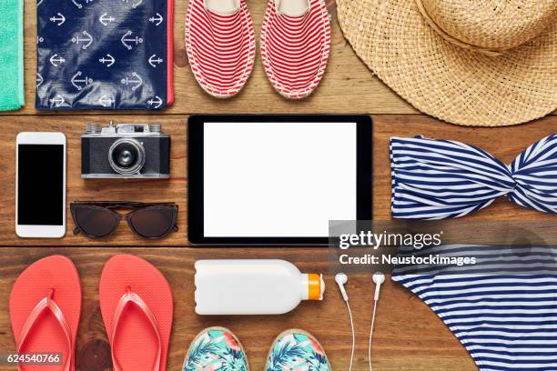 flat lay of digital tablet surrounded with beach accessories - travel essentials stock pictures, royalty-free photos & images