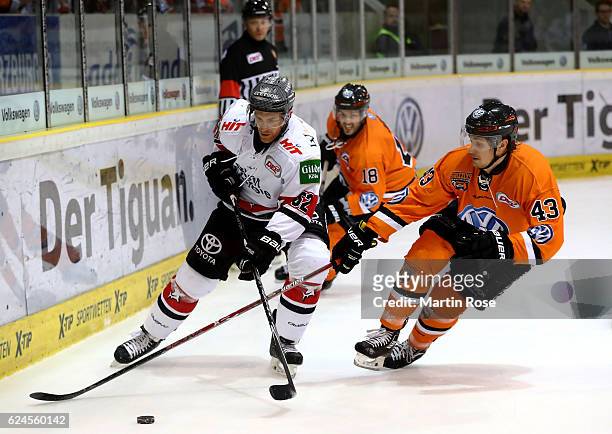 Alexander Weiss of Wolfsburg and Alexander Sulzer of Koeln battle for the puck during the DEL match between Grizzly Wolfsburg and Koelner Haie at...