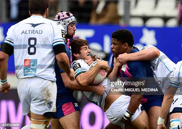 Montpellier's South African fly-half Demetri Catrakilis is tackled by Stade Francais Paris' French centres Jonathan Danty and Theo Millet during the...