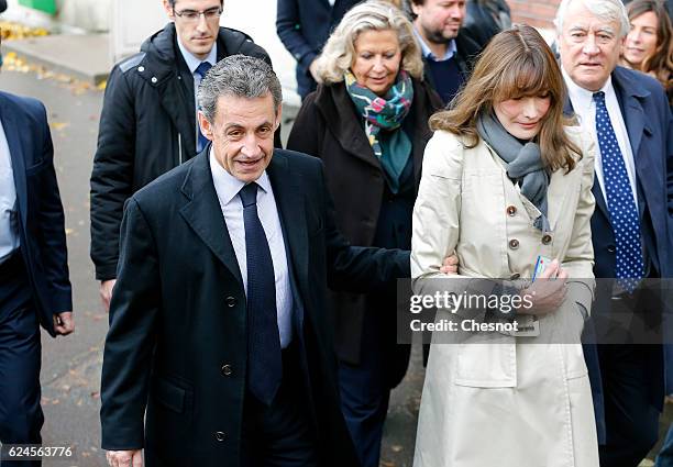 Former French President and presidential candidate hopeful Nicolas Sarkozy and his wife Carla Bruni-Sarkozy leave after casting their votes during...