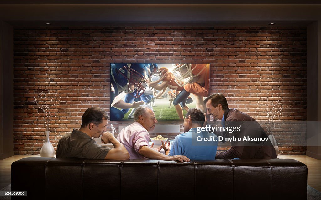 Adults watching American football game at home