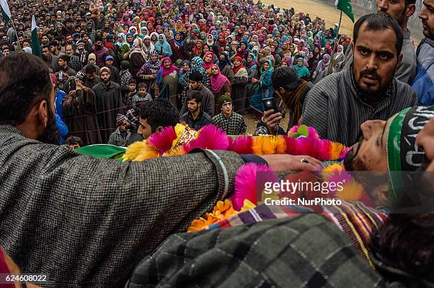 Kashmiri Muslim look towards the body of Rayees Ahmad, a militant who was killed in a gun battle with the Indian government forces, during his...