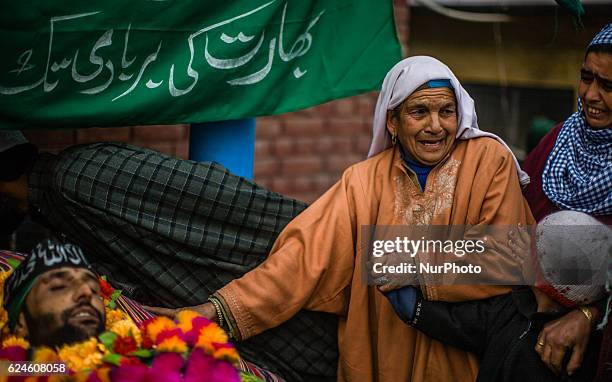 An elderly Kashmiri Muslim woman topuches the body of Rayees Ahmad, a militant who was killed in a gun battle with the Indian government forces,...