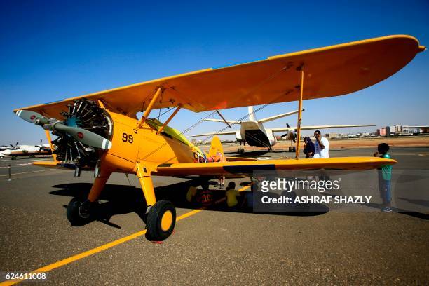 People look at the vintage Boeing-Stearman Model 75 biplane as it sits on the runway on November 20, 2016 in Khartoum airport during the Vintage Air...