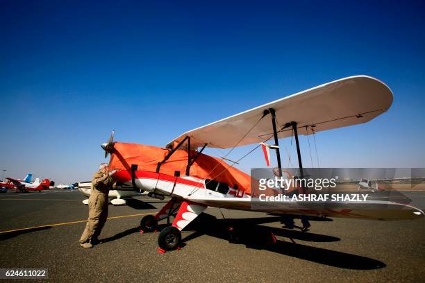 Officials cover the vintage Bucker Bu 131 biplane as it sits on the runway on November 20, 2016 in Khartoum airport during the Vintage Air Rally . -...