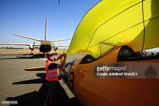An official covers the vintage Boeing-Stearman Model 75 biplane as it sits on the runway on November 20, 2016 in Khartoum airport during the Vintage...