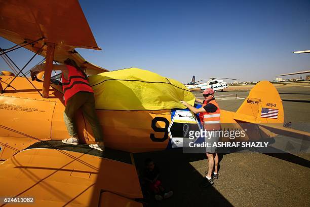 Officials cover the vintage Boeing-Stearman Model 75 biplane as it sits on the runway on November 20, 2016 in Khartoum airport during the Vintage Air...