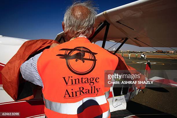 An official covers the vintage Bucker Bu 131 biplane as it sits on the runway on November 20, 2016 in Khartoum airport during the Vintage Air Rally ....