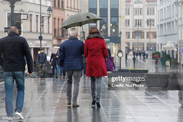 People are seen walking in the old centre of town on a rainy Saturday in Bydgoszcz, Poland on November 19 2016.