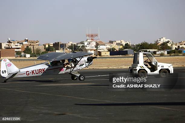 Piper Cub J3L4 aircraft is towed on the runway on November 20, 2016 in Khartoum airport during the Vintage Air Rally . A dozen biplanes from the...