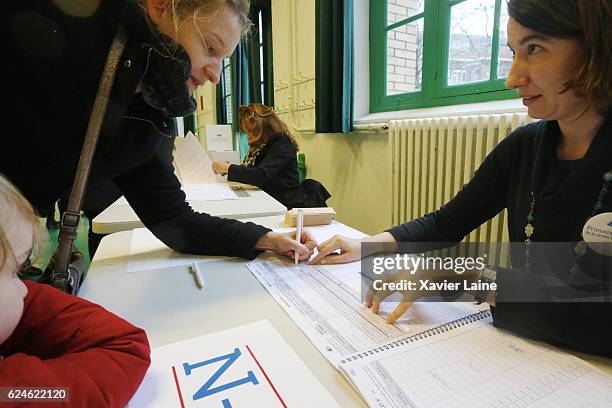 Parisian signs for her vote during the first round of voting in the Republican Party's primary elections at a polling station on November 20, 2016 in...