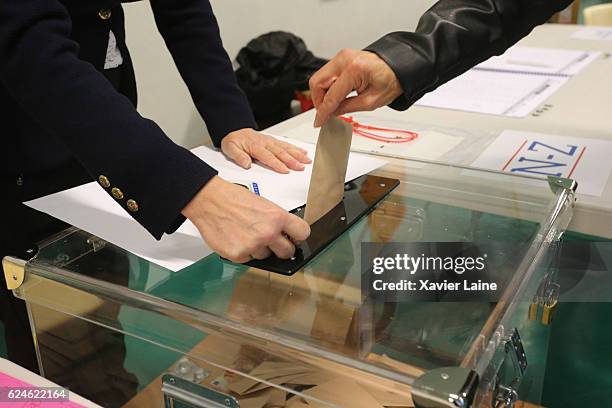 Parisian casts their vote during the first round of voting in the Republican Party's primary elections at a polling station in the 15th...