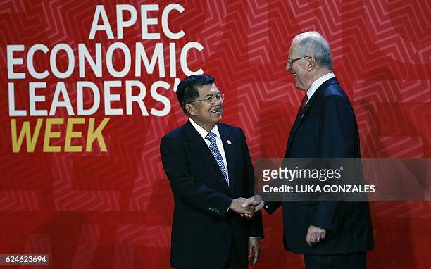 Indonesia's Vice President Jusuf Kalla shakes hands with Peru's President Pedro Pablo Kuczynski upon arrival at the Lima Convention Centre for the...