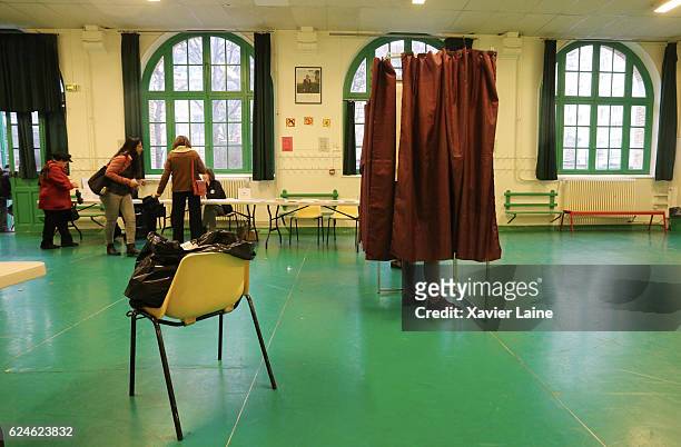 Parisians cast their votes during the first round of voting in the Republican Party's primary elections at a polling station in the 15th...