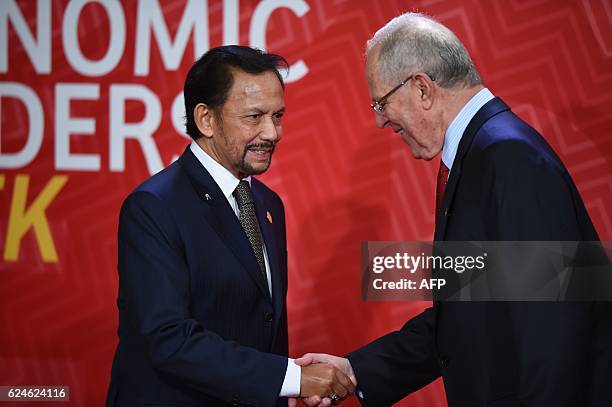 Brunei's Sultan Hassanal Bolkiah shakes hands with Peru's President Pedro Pablo Kuczynski upon arrival at the Lima Convention Centre for the APEC...