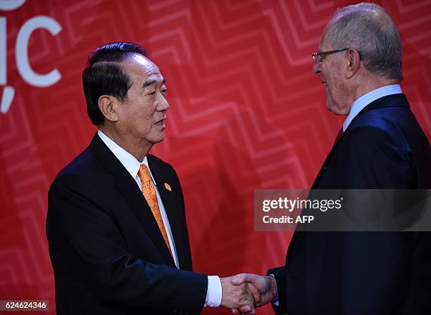 Taiwan's Representative James Soong shakes hands with Peru's President Pedro Pablo Kuczynski upon arrival at the Lima Convention Centre for the APEC...