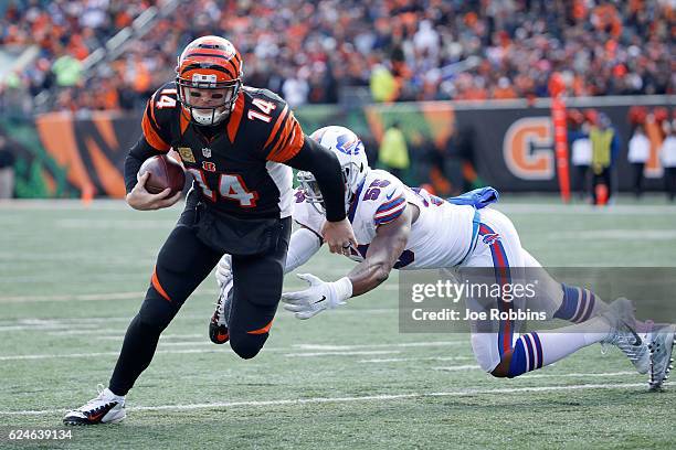Andy Dalton of the Cincinnati Bengals breaks a tackle by Jerry Hughes of the Buffalo Bills and scores a touchdown during the first quarter at Paul...