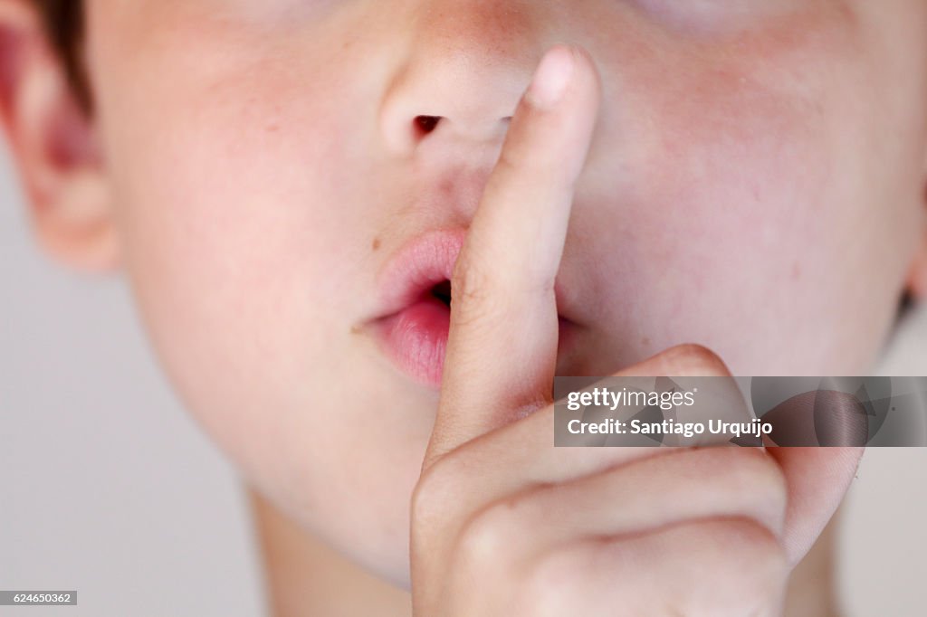 Boy with finger on lips