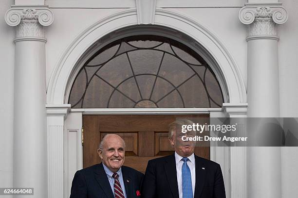 Former New York City mayor Rudy Giuliani stands with president-elect Donald Trump before their meeting at Trump International Golf Club, November 20,...