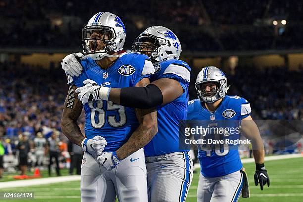 Tight end Eric Ebron of the Detroit Lions celebrates his second half touchdown with teammates Laken Tomlinson and Michael Burton during an NFL game...
