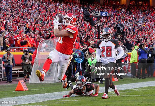 Tight end Travis Kelce of the Kansas City Chiefs tries to high step away from would be tackler strong safety Chris Conte of the Tampa Bay Buccaneers...